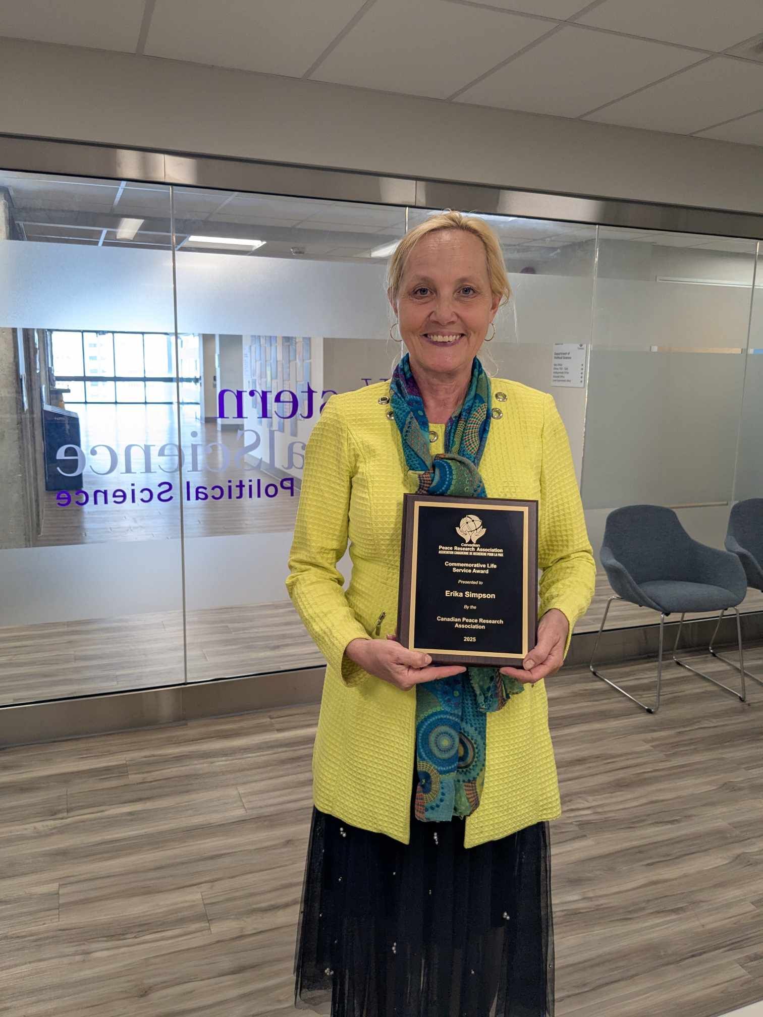 Erika Simpson holding her award plaque