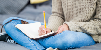 Image of a student writing in a journal